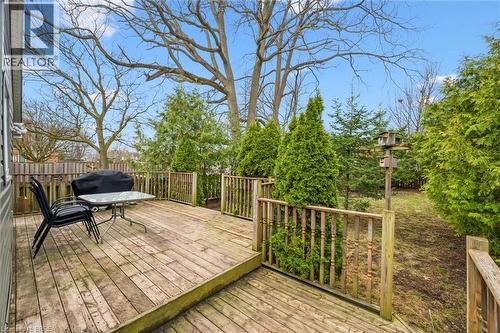 Expansive wooden deck with railing, offering views of mature trees and landscaping - 28 Davidson Street, Cambridge, ON - Outdoor With Deck Patio Veranda