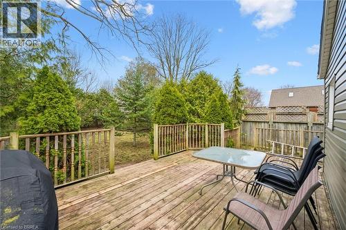 The property features an outdoor wooden deck with a wooden railing, a fenced yard, and a variety of mature trees and shrubs - 28 Davidson Street, Cambridge, ON - Outdoor With Deck Patio Veranda