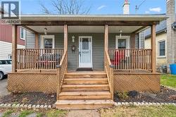 Inviting front porch with wooden railings, steps, and lattice detailing - 