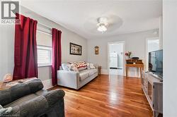 The property features hardwood floors, light gray walls, and a ceiling fan - 