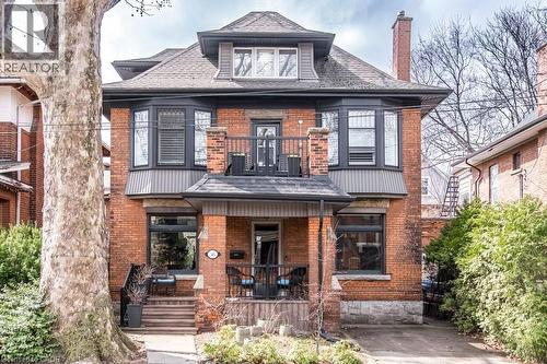 The property features a brick exterior, a covered porch, and bay windows - 36 Eastbourne Avenue, Hamilton, ON - Outdoor