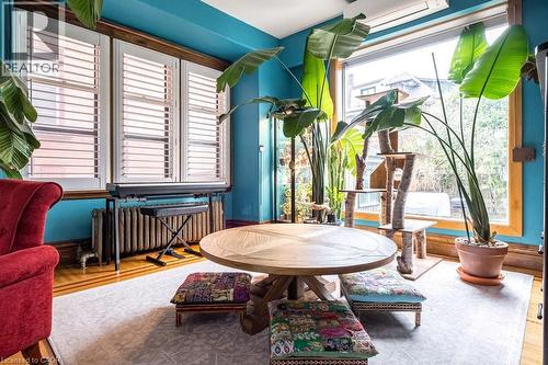 This inviting interior space features lustrous hardwood flooring, complemented by a light-toned area rug - 36 Eastbourne Avenue, Hamilton, ON - Indoor