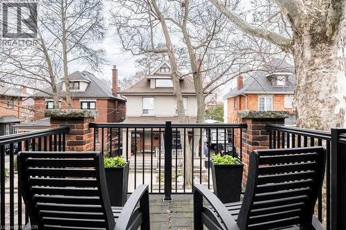 The property features a balcony with black metal railings and brick pillars - 36 Eastbourne Avenue, Hamilton, ON - Outdoor
