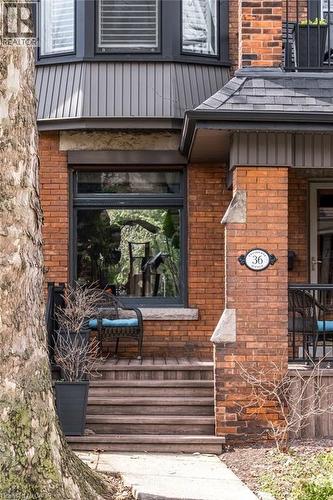 The property features a classic brick exterior with a bay window and a covered front entrance - 36 Eastbourne Avenue, Hamilton, ON - Outdoor With Exterior