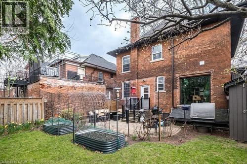 The property features a brick exterior, a spacious backyard with a lawn, and a paved patio area - 36 Eastbourne Avenue, Hamilton, ON - Outdoor With Exterior
