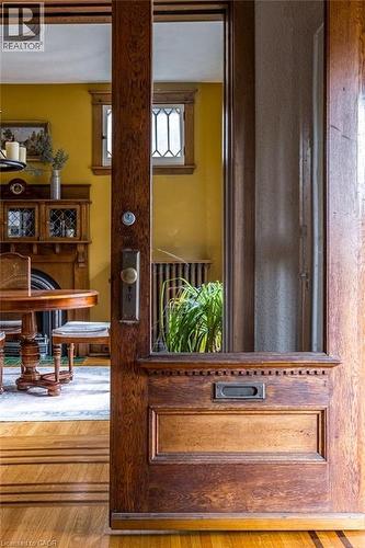 The property features a wood door with glass panels and a mail slot, opening to a room with hardwood floors - 36 Eastbourne Avenue, Hamilton, ON - Indoor Photo Showing Other Room