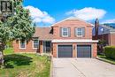 The property features a brick exterior, a two-car garage with dark gray doors, and a paved driveway - 38 Leclaire Street, Hamilton, ON  - Outdoor 