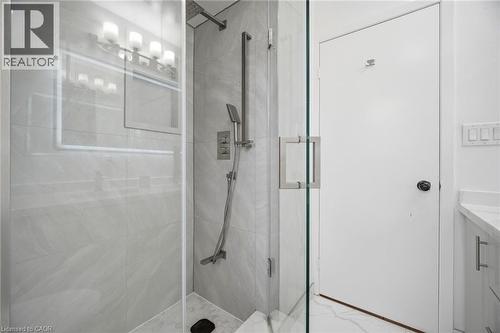 Modern shower with glass enclosure, light-colored tiled walls, and brushed nickel fixtures - 38 Leclaire Street, Hamilton, ON - Indoor Photo Showing Bathroom