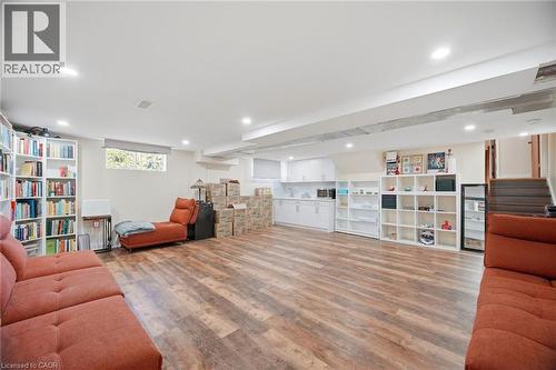 Expansive interior space featuring wood-style flooring, recessed lighting, and a white kitchen area with countertops and cabinetry - 38 Leclaire Street, Hamilton, ON - Indoor