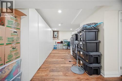 Finished basement area featuring recessed lighting, light wood-style flooring, and built-in white storage cabinets - 38 Leclaire Street, Hamilton, ON - Indoor