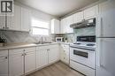 Bright kitchen featuring white cabinetry, a double basin sink, and a light-toned countertop - 212 Westcourt Place, Waterloo, ON  - Indoor Photo Showing Kitchen With Double Sink 