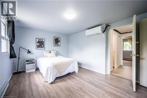 Bright room featuring wood-finish flooring and a single window with dark drapery - 212 Westcourt Place, Waterloo, ON - Indoor Photo Showing Bedroom