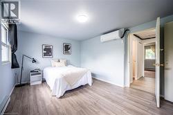 Bright room featuring wood-finish flooring and a single window with dark drapery - 