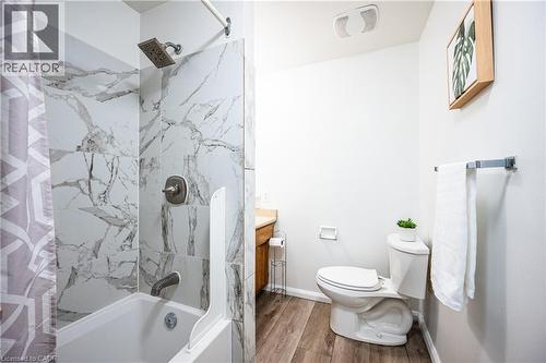 Bathroom featuring a white bathtub with marble-look tile surround and a rain showerhead - 212 Westcourt Place, Waterloo, ON - Indoor Photo Showing Bathroom