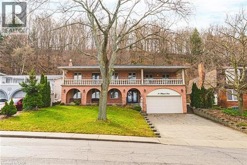 Mediterranean / spanish-style home with a front lawn, concrete driveway, a balcony, a chimney, and an attached garage - 24 Hildegard Drive, Hamilton, ON - Outdoor