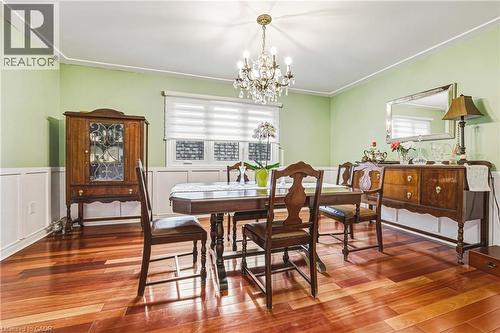 Dining room featuring a chandelier, hardwood / wood-style flooring, plenty of natural light, a wainscoted wall, and ornamental molding - 24 Hildegard Drive, Hamilton, ON - Indoor Photo Showing Dining Room