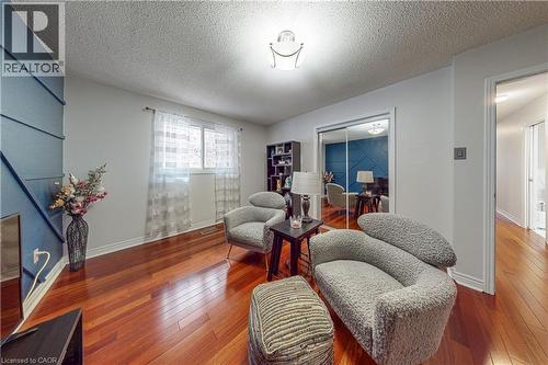 This room features hardwood flooring, a window with sheer curtains, and a ceiling light fixture - 24 Hildegard Drive, Hamilton, ON - Indoor Photo Showing Living Room