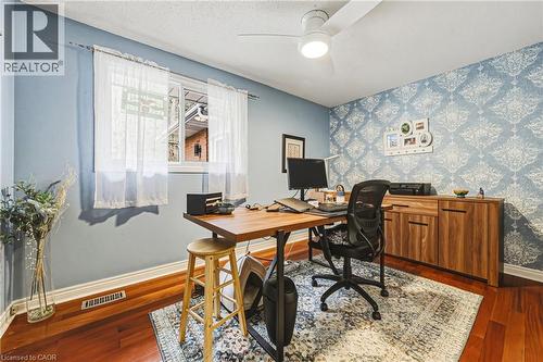 Office space with wallpapered walls, dark wood finished floors, an accent wall, a textured ceiling, and ceiling fan - 24 Hildegard Drive, Hamilton, ON - Indoor Photo Showing Office