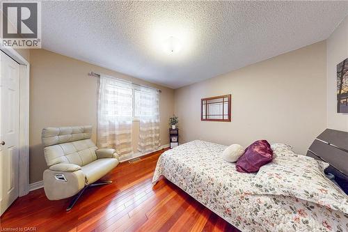 Bedroom with a textured ceiling, hardwood / wood-style flooring, and a closet - 24 Hildegard Drive, Hamilton, ON - Indoor Photo Showing Bedroom