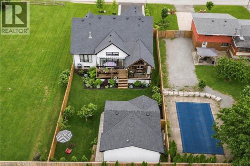 Modern residence featuring a multi-level deck, covered outdoor living space, and a detached structure - 253 Central Avenue, Grimsby, ON 