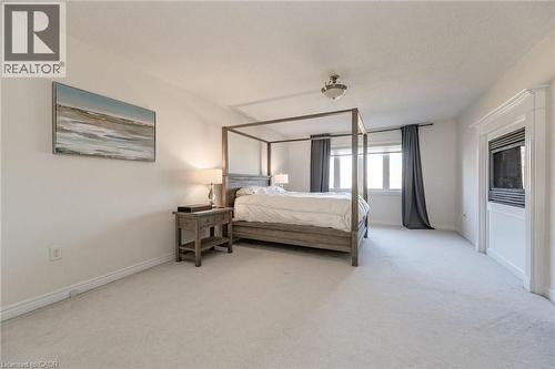 The room features light-colored carpeting, white walls, and a window with dark curtains - 2453 Village Common, Oakville, ON - Indoor Photo Showing Bedroom