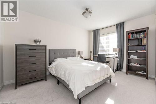 The bedroom features light-colored walls and carpeting, a window with blinds and dark curtains, and a ceiling-mounted light fixture - 2453 Village Common, Oakville, ON - Indoor Photo Showing Bedroom