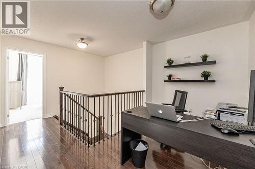 Upper level landing featuring dark hardwood floors and a white railing with black spindles - 2453 Village Common, Oakville, ON - Indoor Photo Showing Other Room