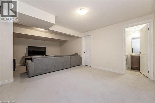 Expansive room featuring light-colored carpeting, recessed lighting, and a white door leading to a bathroom with a vanity and tiled flooring - 2453 Village Common, Oakville, ON - Indoor Photo Showing Other Room