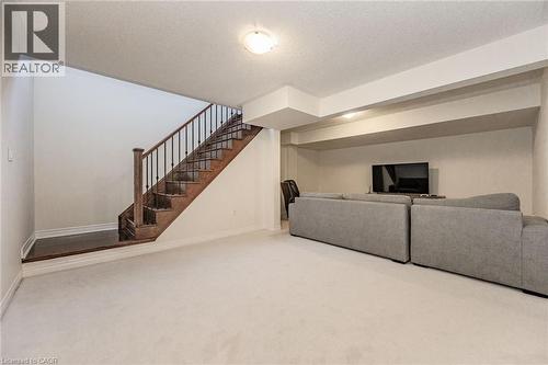 Recreation area featuring light-colored carpeting, a wooden staircase with black metal balusters, and recessed lighting - 2453 Village Common, Oakville, ON - Indoor