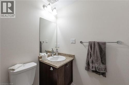 Bathroom featuring a corner vanity with a granite countertop, undermount sink, and a dark wood cabinet - 2453 Village Common, Oakville, ON - Indoor Photo Showing Bathroom