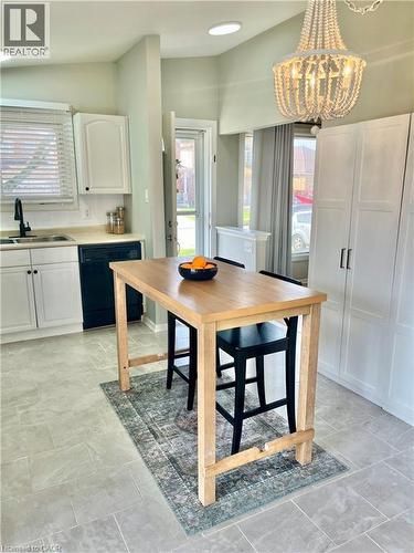 The kitchen features light-colored flooring, white cabinetry, and a light wood-toned island - 241 Thorner Drive, Hamilton, ON - Indoor Photo Showing Other Room