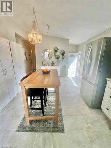 Kitchen area featuring light-colored tile flooring, a central wooden island, and stainless steel appliances - 241 Thorner Drive, Hamilton, ON - Indoor Photo Showing Other Room