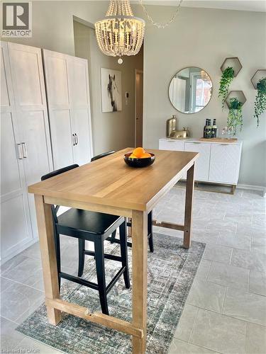 This bright space features light tile flooring and a decorative chandelier - 241 Thorner Drive, Hamilton, ON - Indoor Photo Showing Dining Room