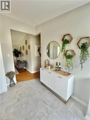 The entry features light-toned tiled flooring and leads into a space with hardwood flooring - 241 Thorner Drive, Hamilton, ON - Indoor Photo Showing Bathroom