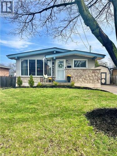 The property features a well-maintained lawn with a stone facade accent, a light blue roofline, and a prominent front window - 241 Thorner Drive, Hamilton, ON - Outdoor With Deck Patio Veranda