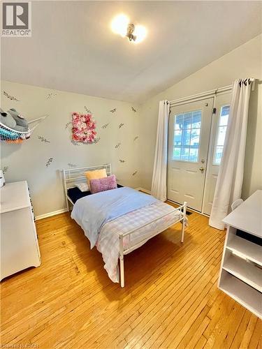 This room features wood floors and a glass-paned door, providing exterior access - 241 Thorner Drive, Hamilton, ON - Indoor Photo Showing Bedroom