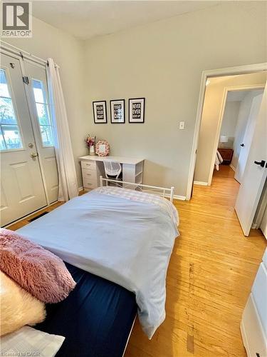 This room features hardwood floors and a set of white double doors with glass inserts - 241 Thorner Drive, Hamilton, ON - Indoor Photo Showing Bedroom