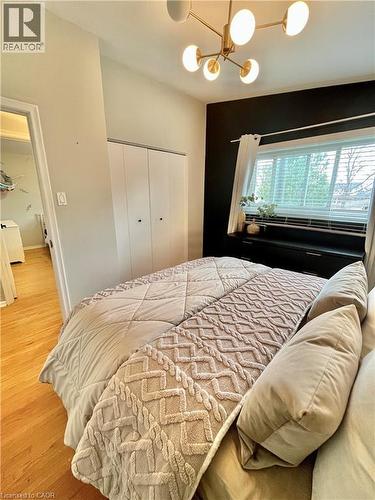 This room features light hardwood flooring, a ceiling light fixture with multiple globes, and a window with blinds - 241 Thorner Drive, Hamilton, ON - Indoor Photo Showing Bedroom