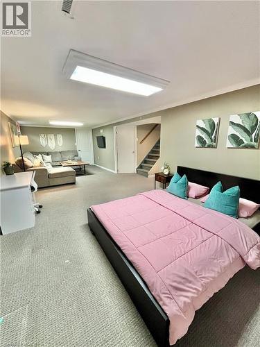 This versatile space features carpeting, a bed, and a staircase - 241 Thorner Drive, Hamilton, ON - Indoor Photo Showing Bedroom