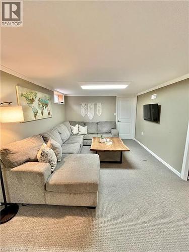 Spacious living area featuring light-colored carpeting, a wall-mounted television, and a window providing natural light - 241 Thorner Drive, Hamilton, ON - Indoor Photo Showing Living Room