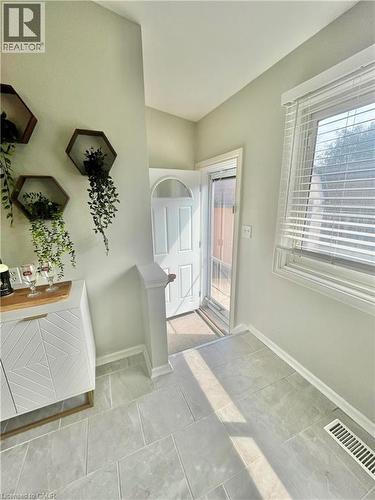 Bright entry area featuring light-colored tile flooring, a white window with blinds, and a white front door with an arched glass panel - 241 Thorner Drive, Hamilton, ON - Indoor Photo Showing Other Room