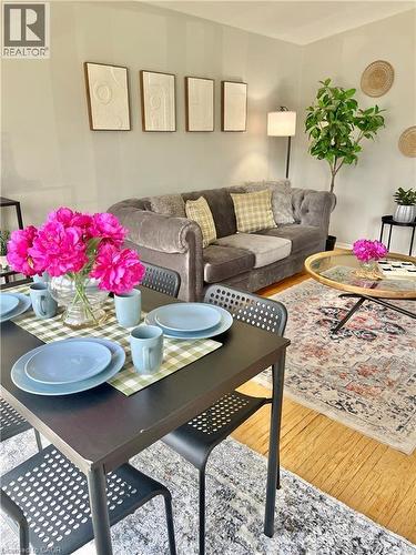 The property features a dining area with a dark rectangular table and chairs, set against a backdrop of light wood flooring - 241 Thorner Drive, Hamilton, ON - Indoor Photo Showing Living Room