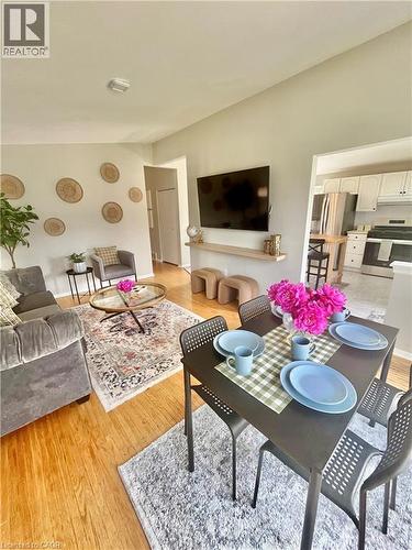 This open-concept living and dining area features hardwood flooring and light-colored walls, creating a bright and inviting atmosphere - 241 Thorner Drive, Hamilton, ON - Indoor Photo Showing Living Room