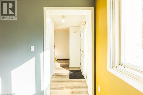 The property features an entryway with light-toned flooring, a white front door with decorative glass, and a large window providing natural light - 121 University Avenue E Unit# 102, Waterloo, ON - Indoor Photo Showing Other Room
