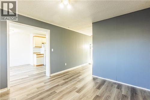 The property features light wood-look flooring throughout, complemented by grey walls - 121 University Avenue E Unit# 102, Waterloo, ON - Indoor Photo Showing Other Room