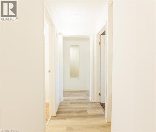 Hallway featuring light-toned flooring, white walls, and a recessed mirror - 121 University Avenue E Unit# 102, Waterloo, ON - Indoor Photo Showing Other Room