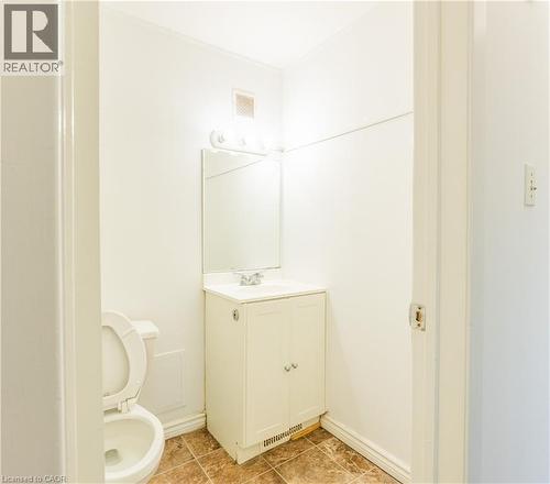 The bathroom features a vanity with a sink, a mirror, and a toilet - 121 University Avenue E Unit# 102, Waterloo, ON - Indoor Photo Showing Bathroom