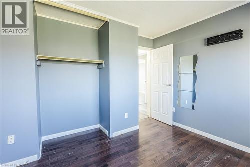 This room features dark hardwood flooring, light blue walls, and white trim - 121 University Avenue E Unit# 102, Waterloo, ON - Indoor Photo Showing Other Room