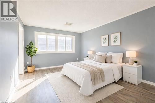 This room features light-colored walls, wood-style flooring, and a large window - 121 University Avenue E Unit# 102, Waterloo, ON - Indoor Photo Showing Bedroom