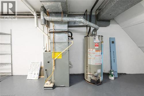 The property includes a water heater and furnace, along with visible ductwork and piping - 121 University Avenue E Unit# 102, Waterloo, ON - Indoor Photo Showing Basement